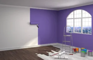 A bright purple feature wall being painted in a city apartment, using high-quality paint to resist paint fading in UAE caused by sunlight and humidity.