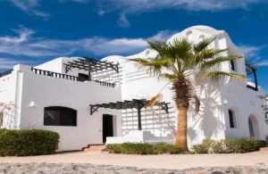 A white-painted villa with modern architecture under a clear blue sky, showcasing premium exterior paint durability in a hot climate.